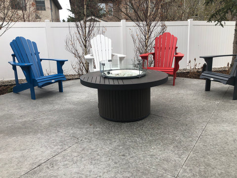 Outdoor GreatRoom Brooks Round Fire Table - Sitting outside on a patio with some lovely Adirondack chairs.  Great to add some ambiance and heat to our outdoor patio parties | Available at Barbecues Galore: Burlington, Oakville, Etobicoke & Calgary 